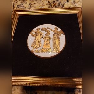 Vintage gold and white porcelain medallion framed on black velvet.